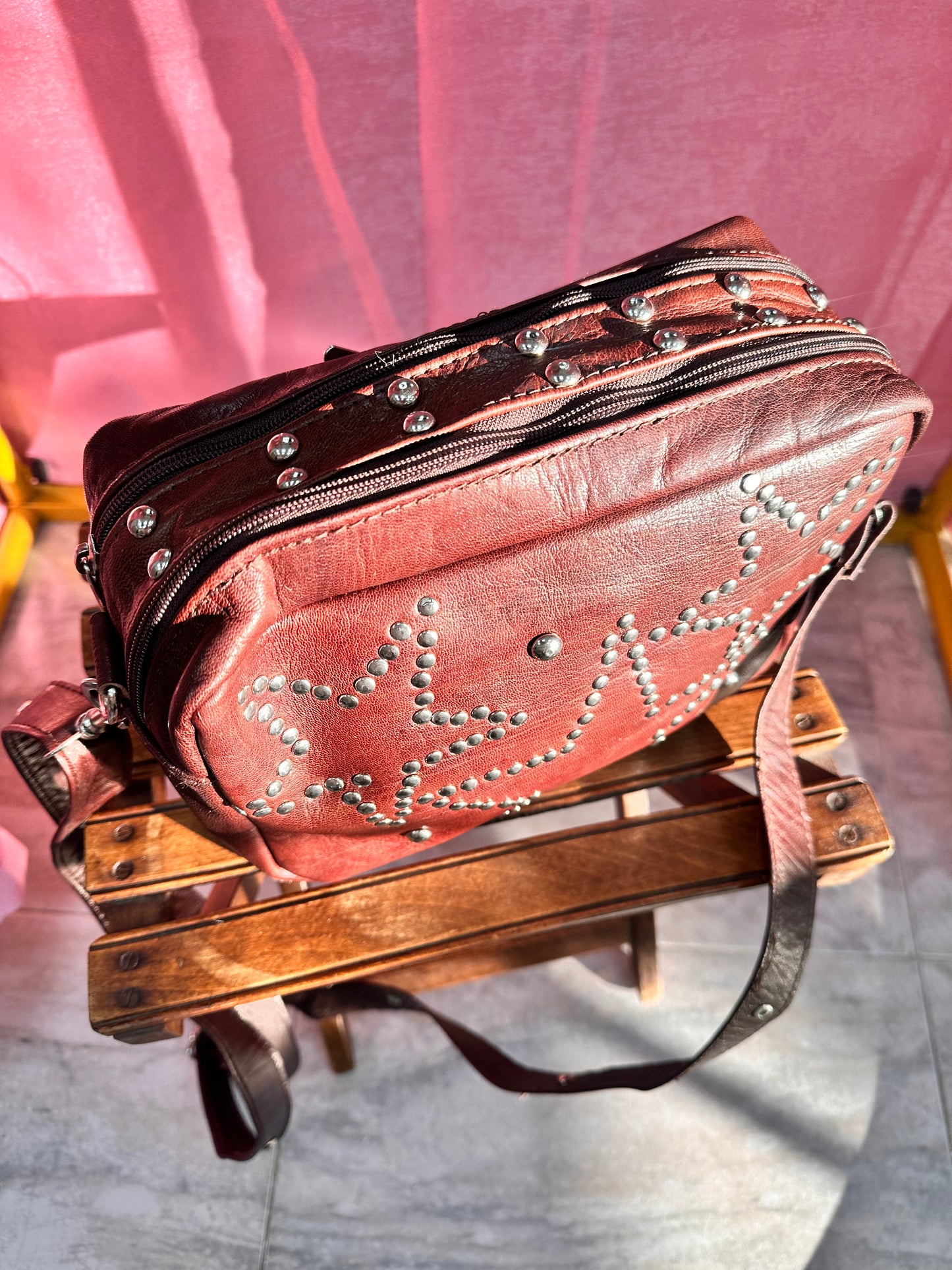 Bolso marrón de cuero con tachuelas diseño estrellas