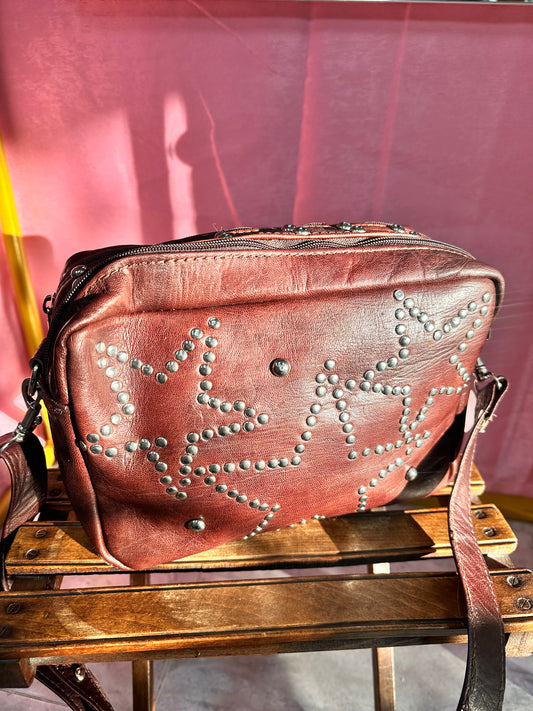 Bolso marrón de cuero con tachuelas diseño estrellas