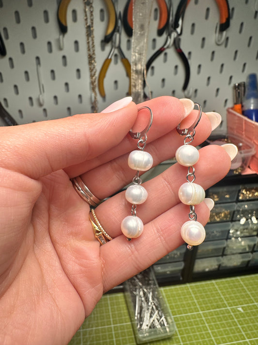 Pendientes largos plateados con tres perlas
